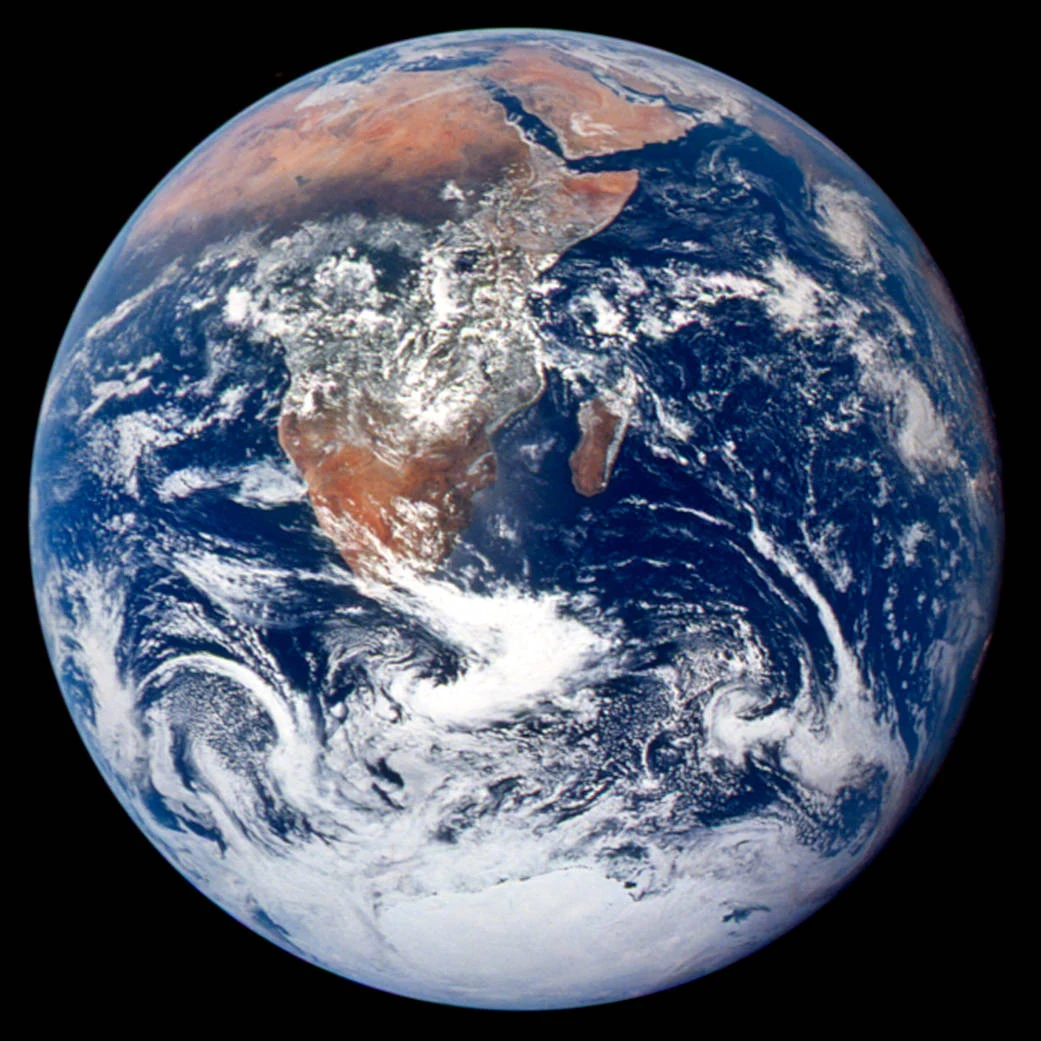 The whole Earth, with Africa, blue oceans, and swirling white clouds against space.